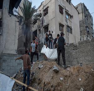 مواطنون يخلون ضحايا من منزل تعرض للقصف في مدينة غزة